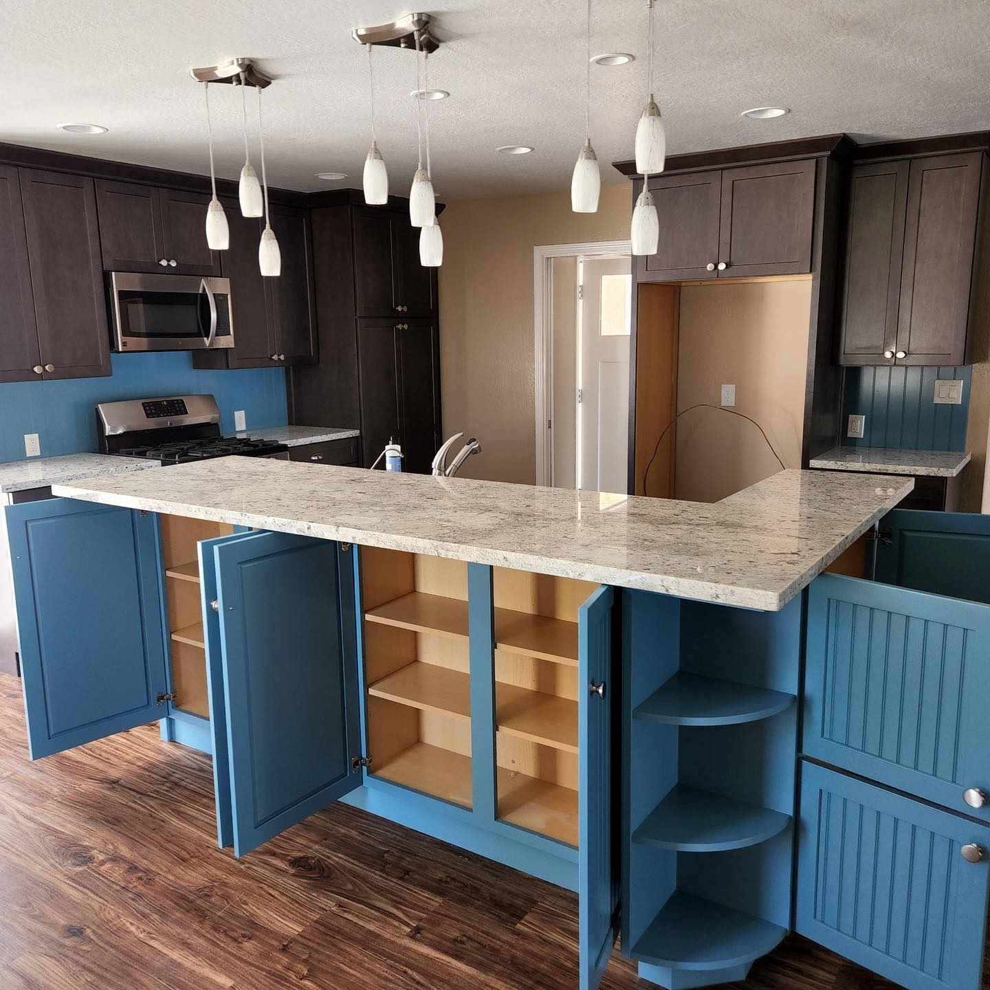 cabinets with classic walnut stain and modern blue island